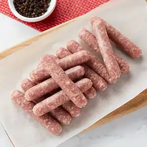 Thin sausages filled in 28mm collagen casing, stacked on parchment
