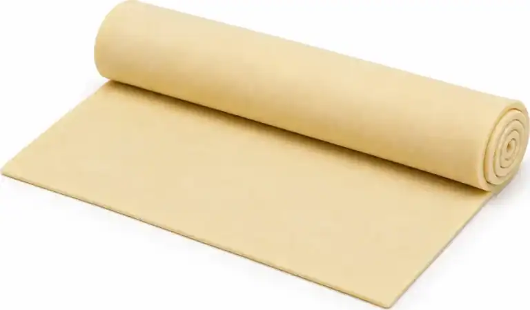 Sheet of pastry partly unrolled from a chilled pastry roll