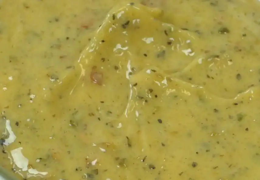 Close-up of RAPS Chinese Salt and Pepper marinade, a yellow paste flecked with black pepper and herbs
