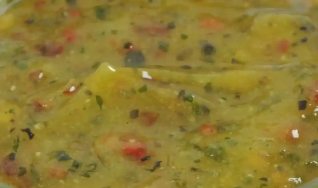Close-up of RAPS Ginger, Chilli and Lime marinade, a pale gold paste with red chilli and herb pieces