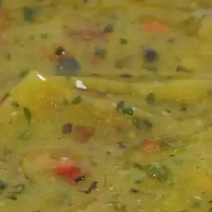 Close-up of RAPS Ginger, Chilli and Lime marinade, a pale gold paste with red chilli and herb pieces