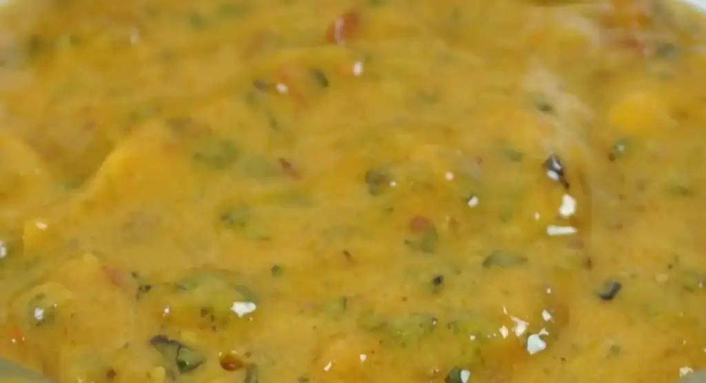 Close-up of RAPS Lemon and Chilli marinade, a golden paste flecked with herbs and chilli