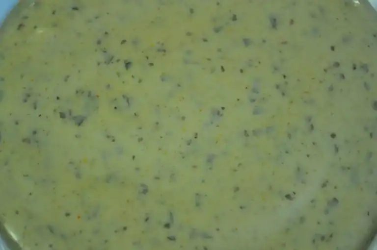 Close-up of RAPS Marinox French Garlic marinade, a pale creamy sauce with chopped garlic pieces