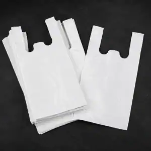 Plain white vest carrier bags, a single bag laid over a folded stack