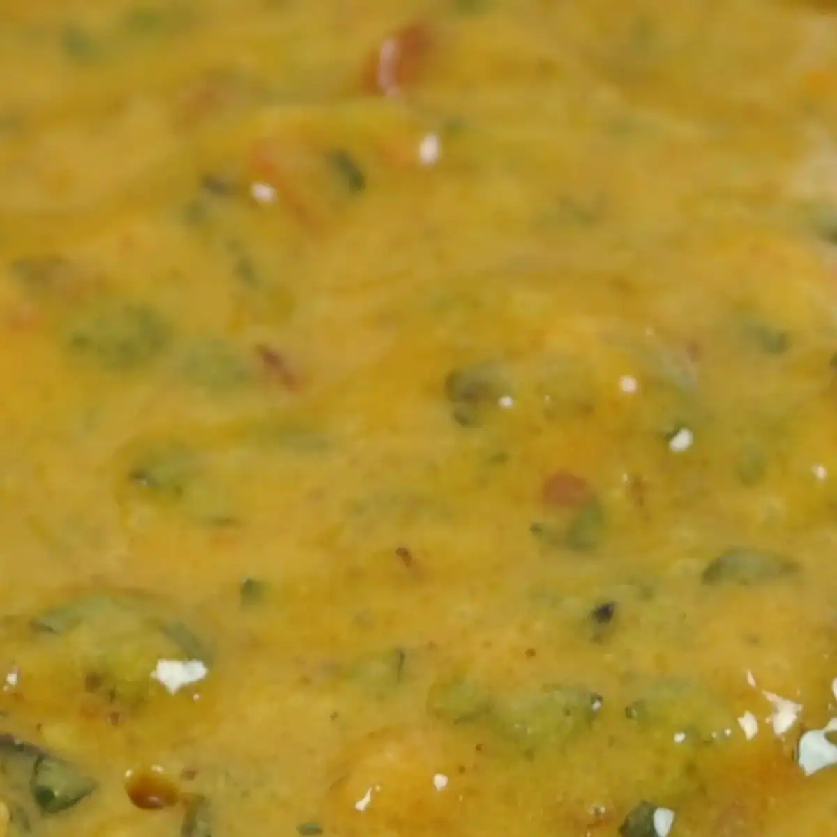 Close-up of RAPS Lemon and Chilli marinade, a golden paste flecked with herbs and chilli